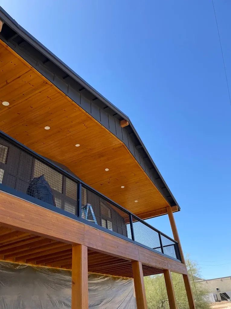 Stained wood porch ceiling and dark trim on a new home