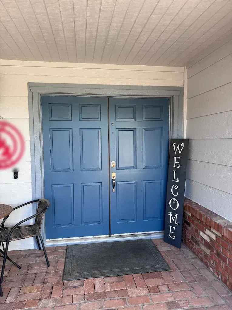 Double front doors painted a deep blue with gray trim