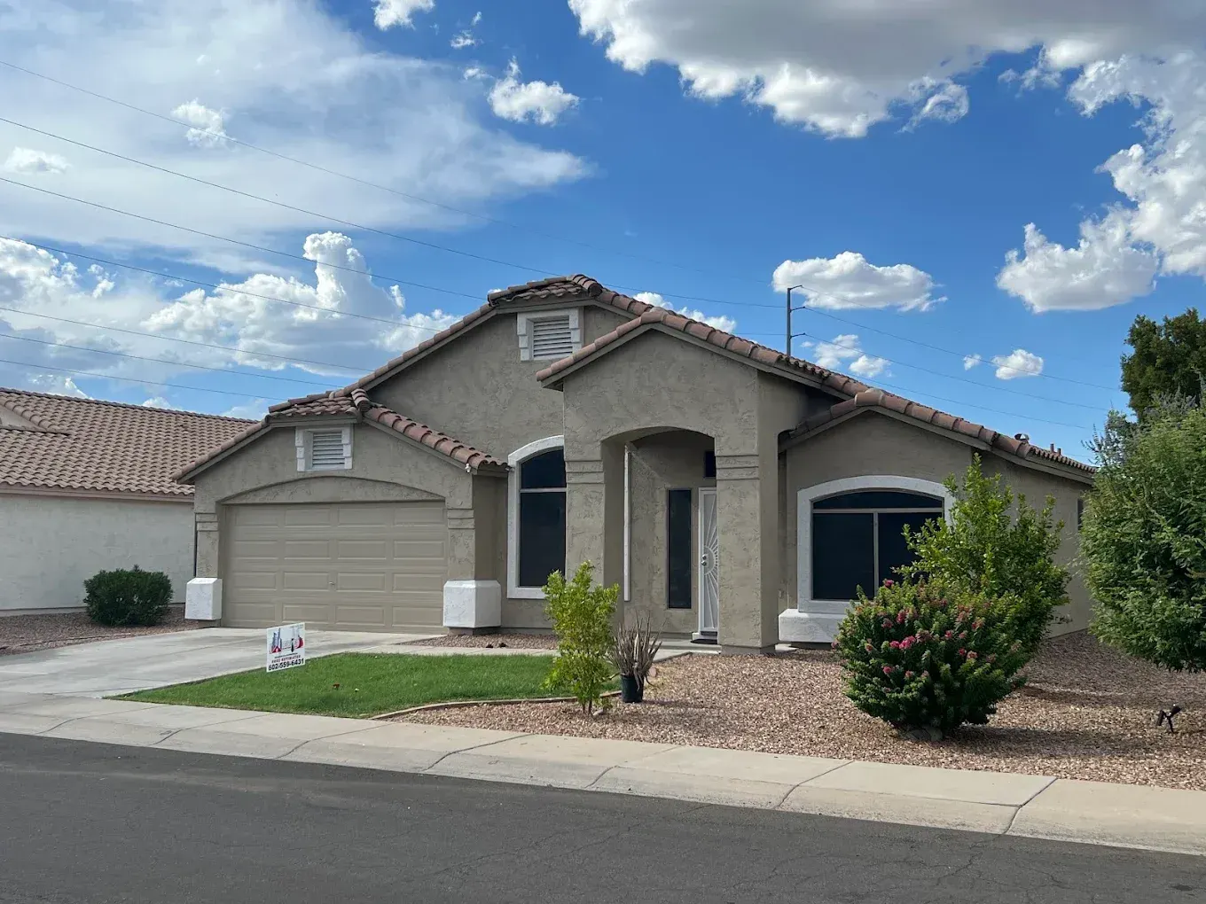 Two-tone stucco home with white trim and an Executive Painting free-estimates yard sign