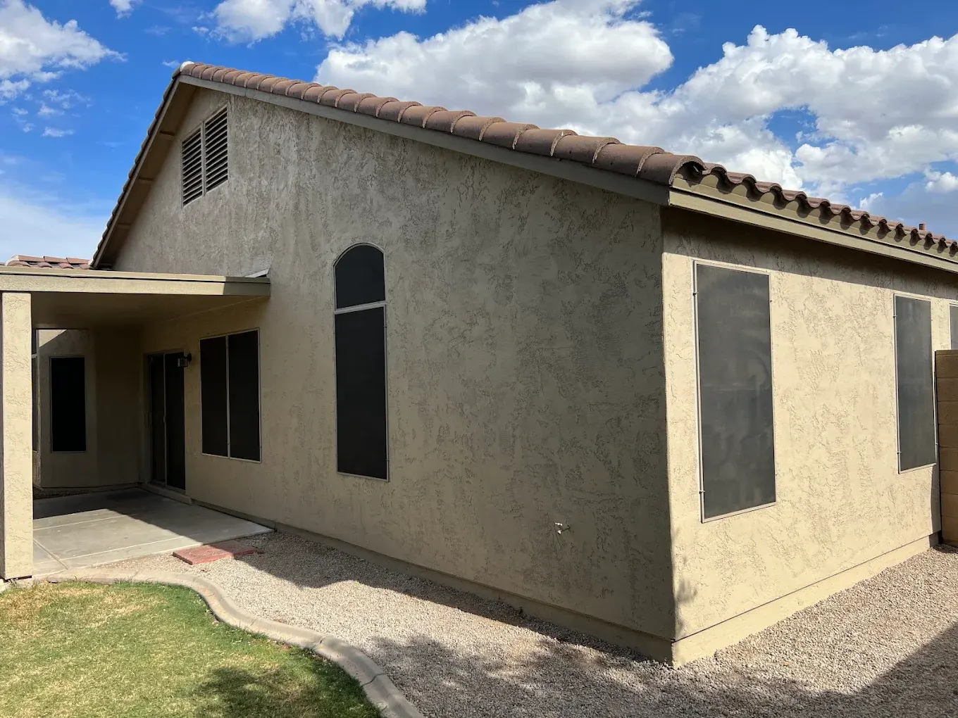 Side of a home with freshly painted textured stucco and trim
